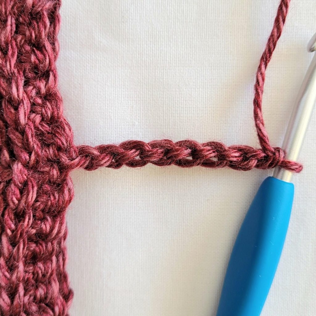 Beginning the sleeve trim by chaining eight stitches for the crochet cardigan pattern