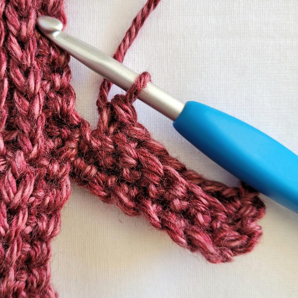 Single crochet stitches worked in the back loop only to form ribbed sleeve trim