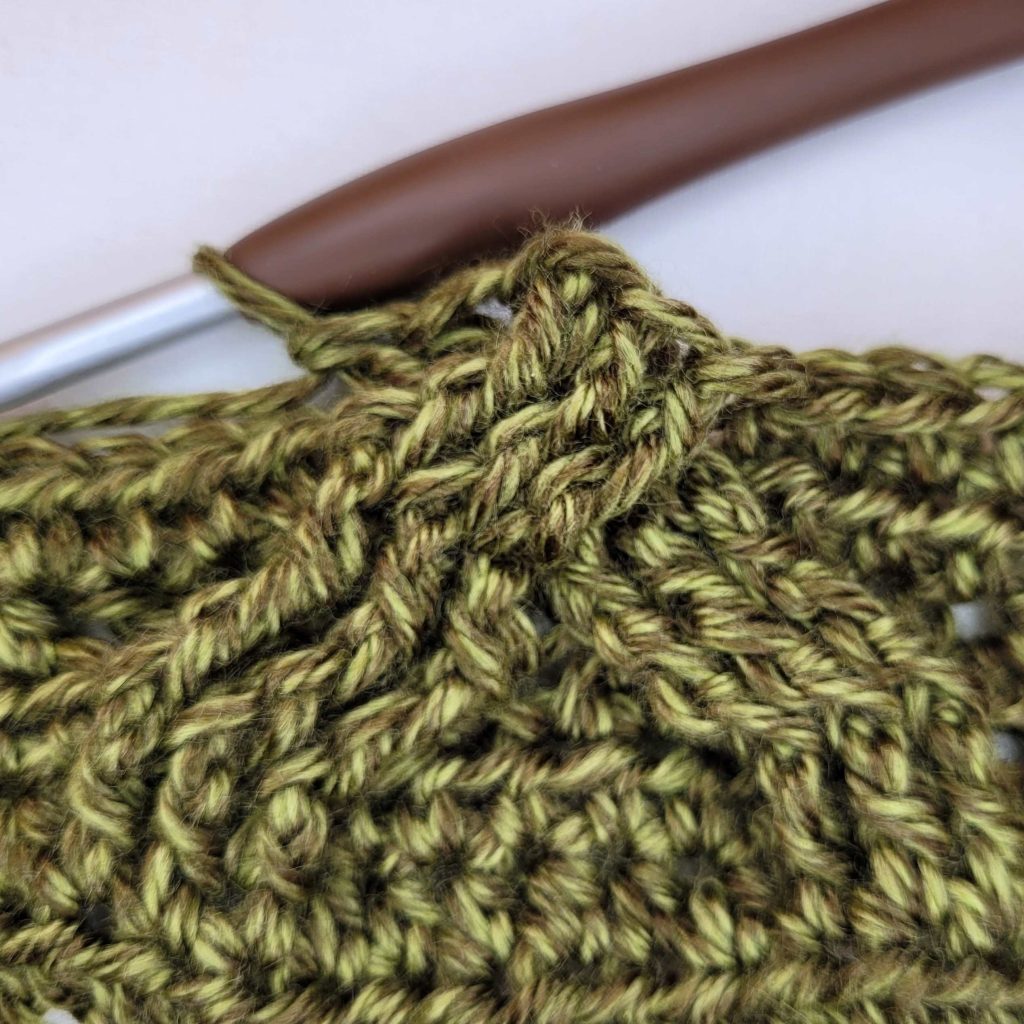 Instructional photo that shows how to make the Morgaine Sweater Scarf With Sleeves. 