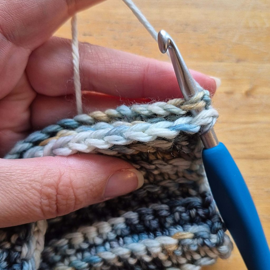 In-progress crochet sweater scarf showing textured fabric and stitch pattern