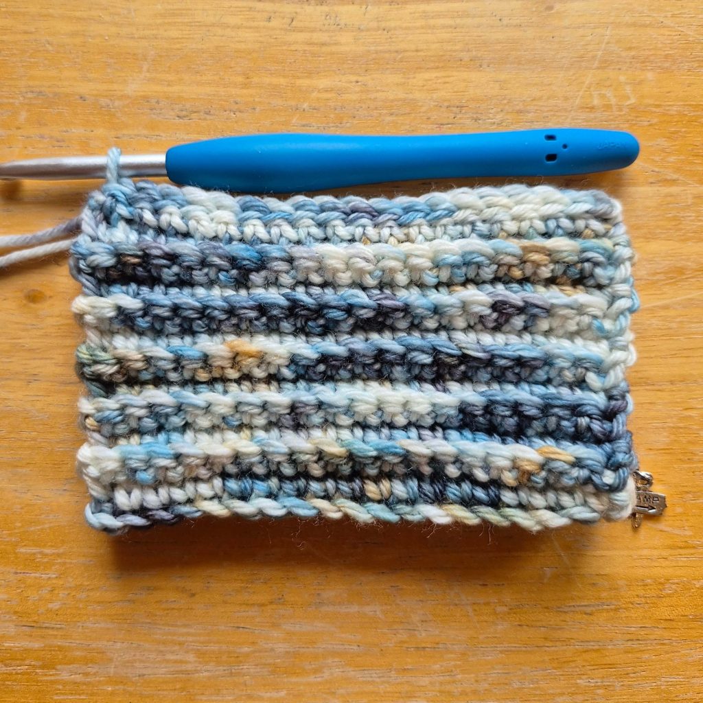 In-progress crochet sweater scarf showing textured fabric and stitch pattern