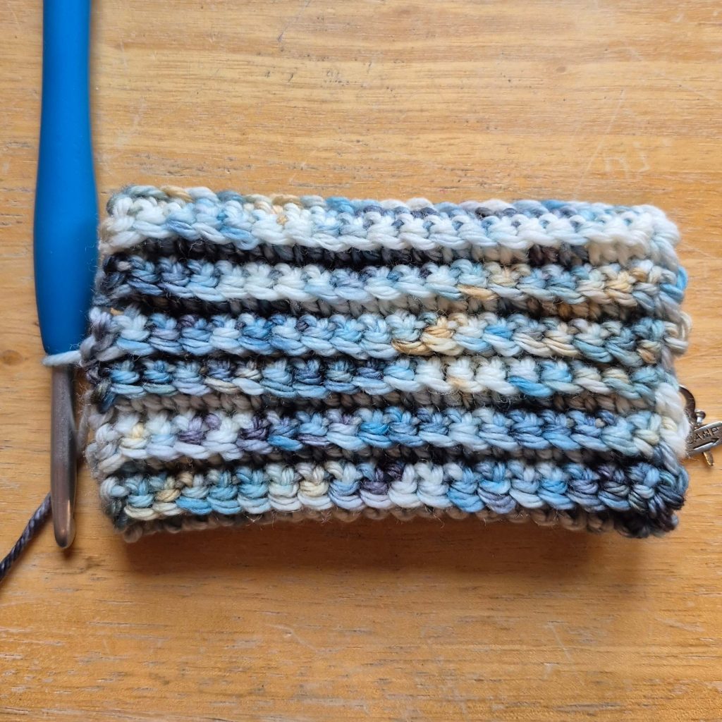 In-progress crochet sweater scarf showing textured fabric and stitch pattern