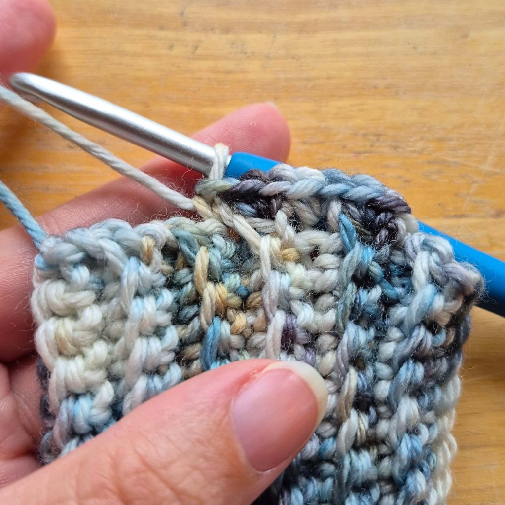 Detail photo of crochet sweater scarf construction and stitch texture