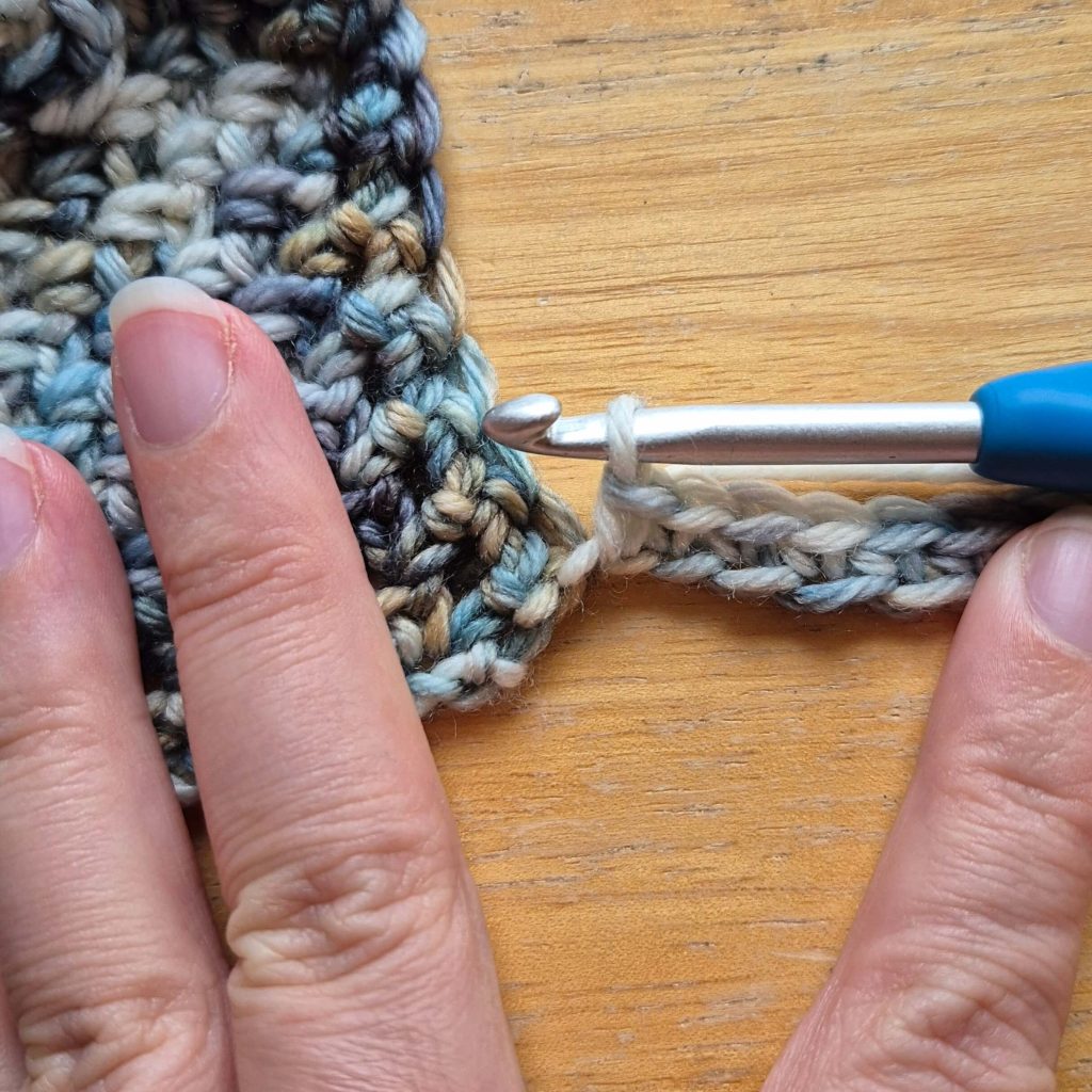 In-progress crochet sweater scarf showing textured fabric and stitch pattern