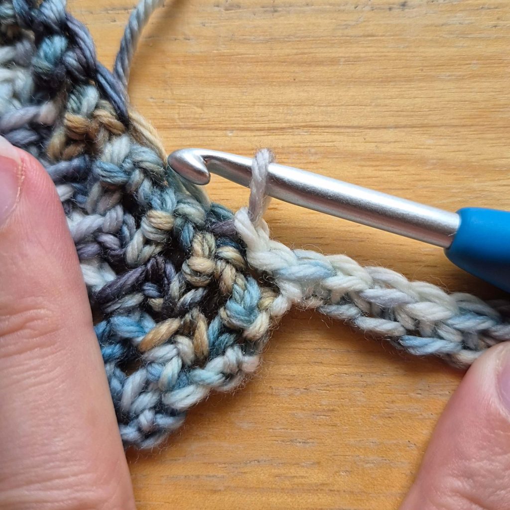 In-progress crochet sweater scarf showing textured fabric and stitch pattern