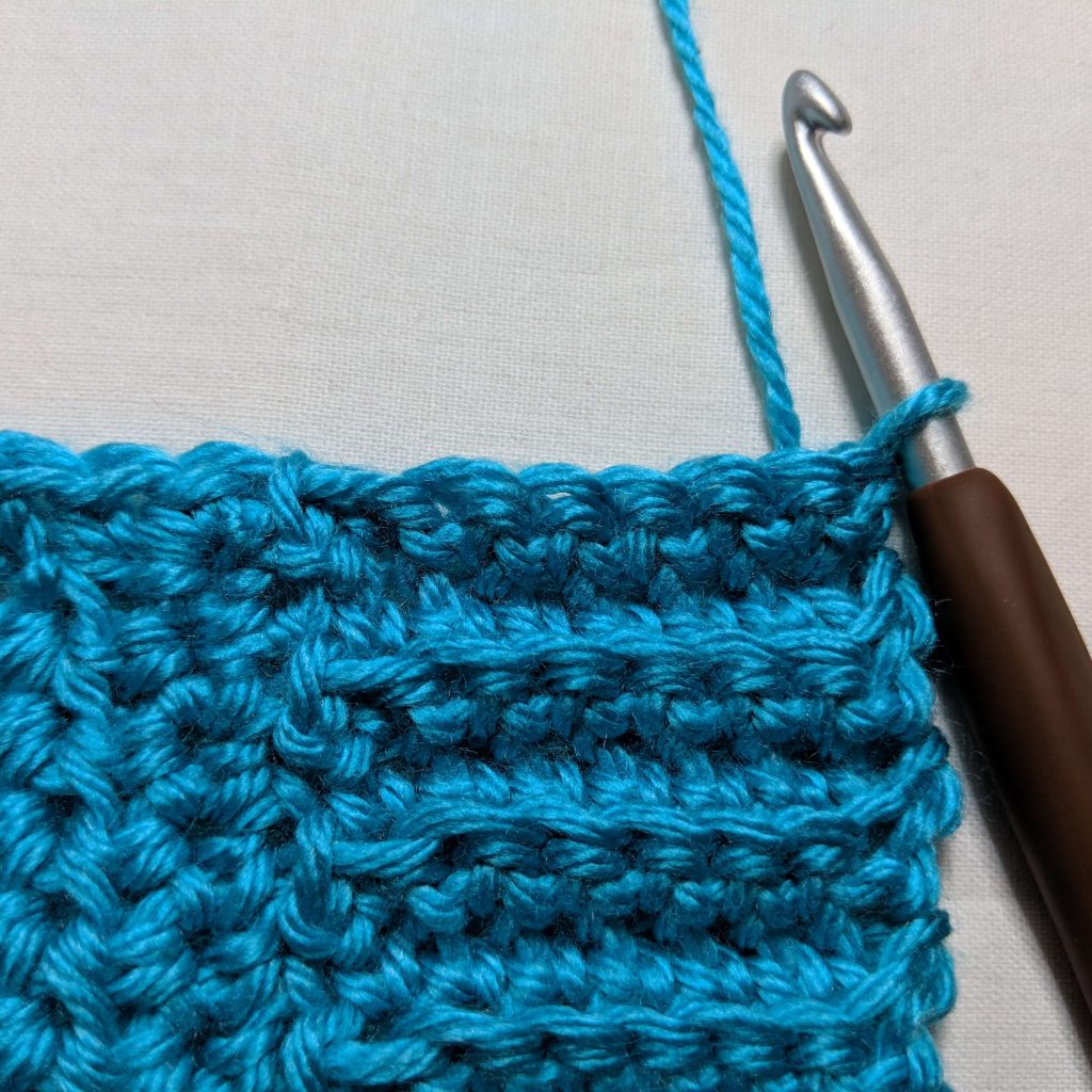 Completed ribbed trim along the bottom edge of the crochet cardigan before turning