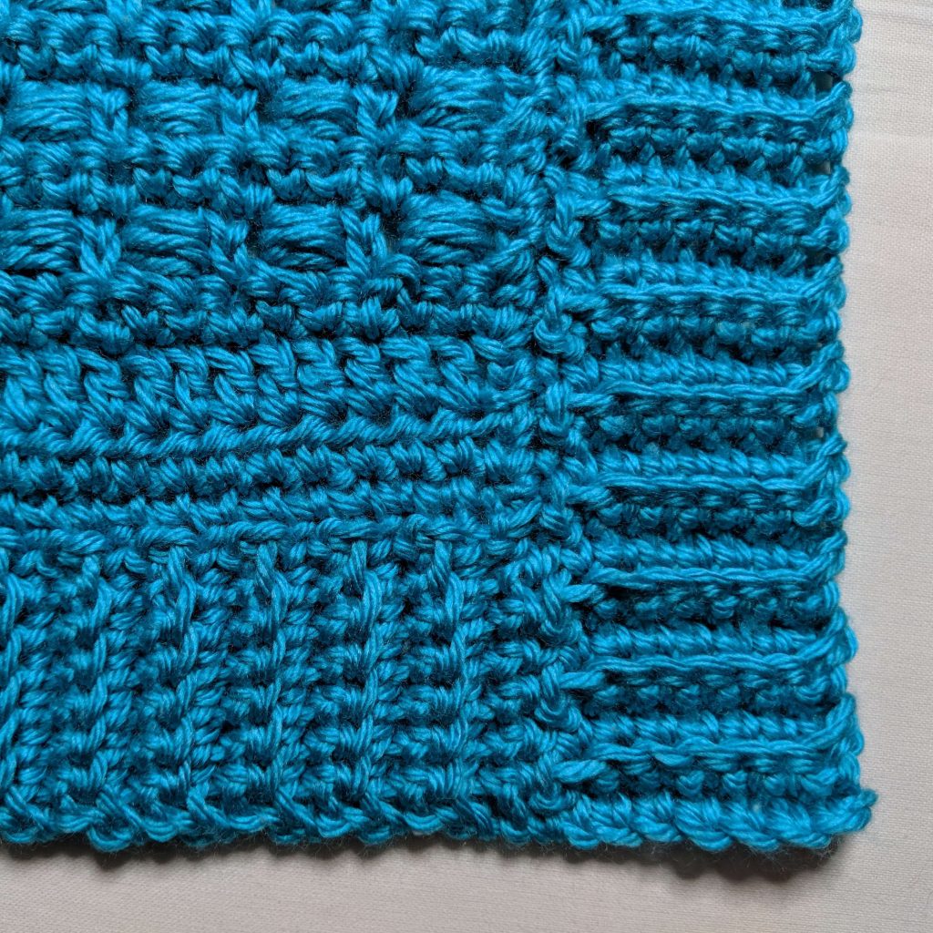 Finished corner detail where body trim meets front panel trim on crochet cardigan