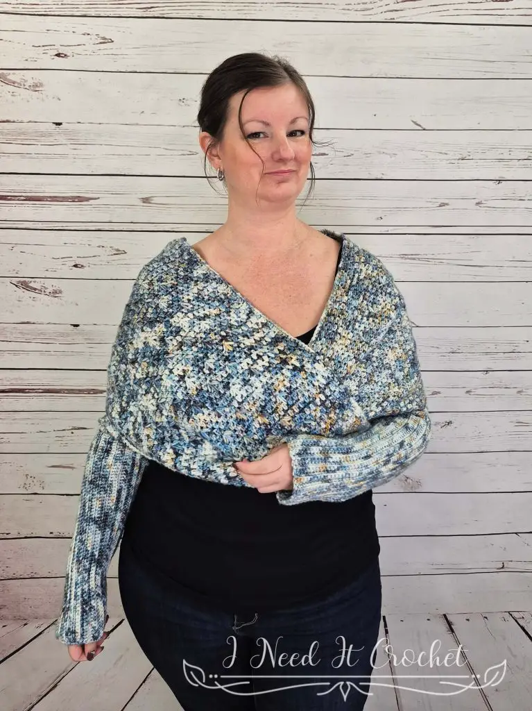 Textured crochet sweater scarf styled as a cozy wrap in soft blue yarn